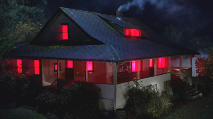 Cain's house glows red as he massacres the demon army sent for him.
